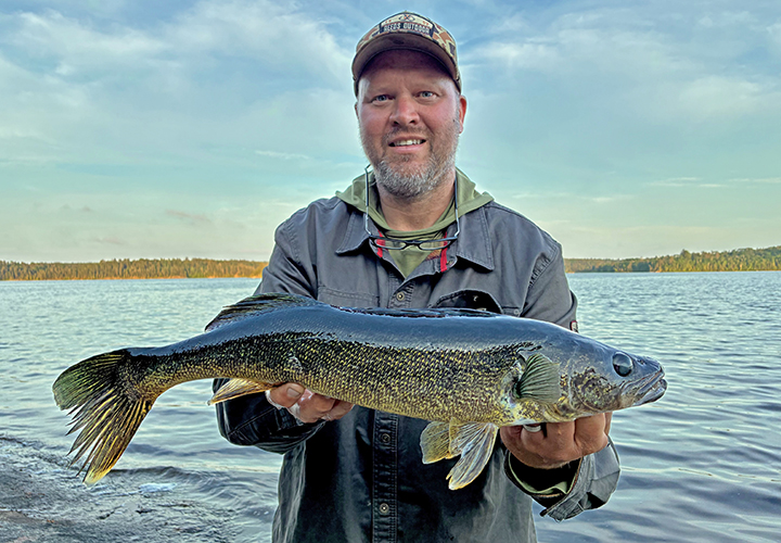 image of walleye fisherman holding big fish he caught near Ely Minnesota