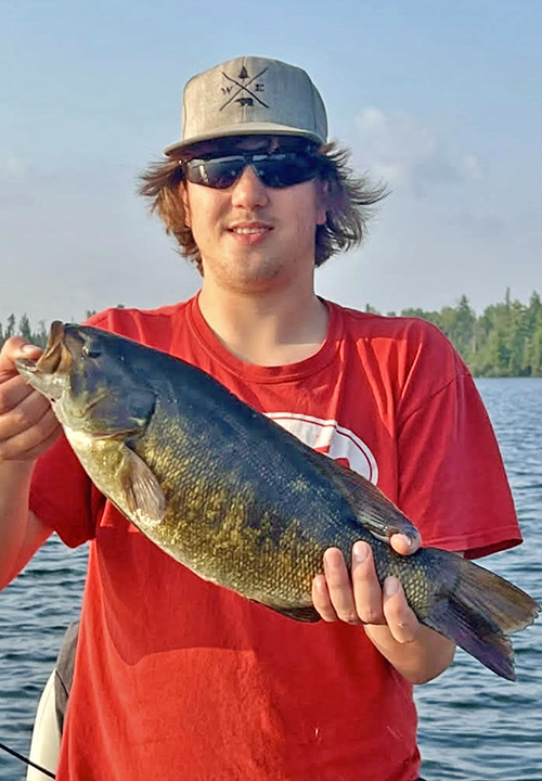 image of young man holding nice smallmouth bass