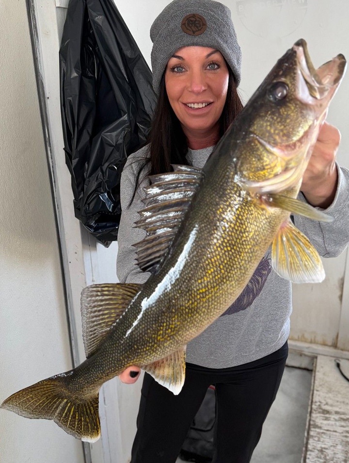image of woman with big walleye she caught while ice fishing on Lake of the Woods