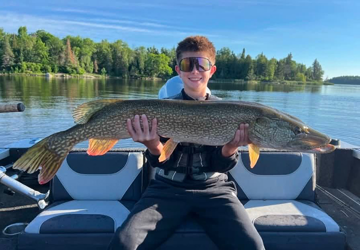 image of young man with huge northern pike he caught in the northwest angle