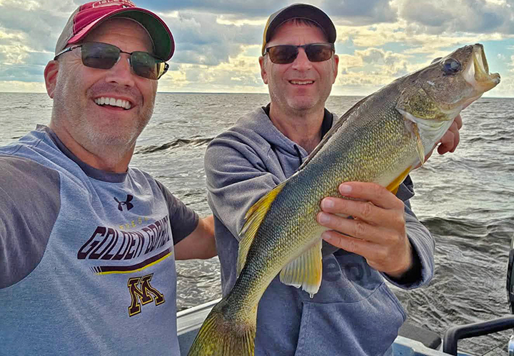 image of 2 anglers showing off a large walleye caught on Lake of the Woods 