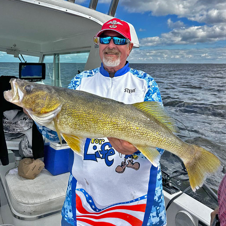 image of angler holding a huge walleye he caught on Lake of the Woods fishing charter