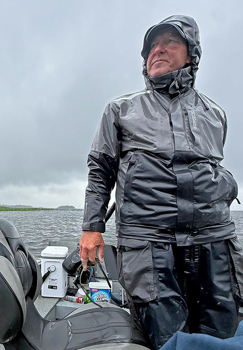 Professional guide Jeff Sundin at the tiller on a rainy day at Bowstring Lake