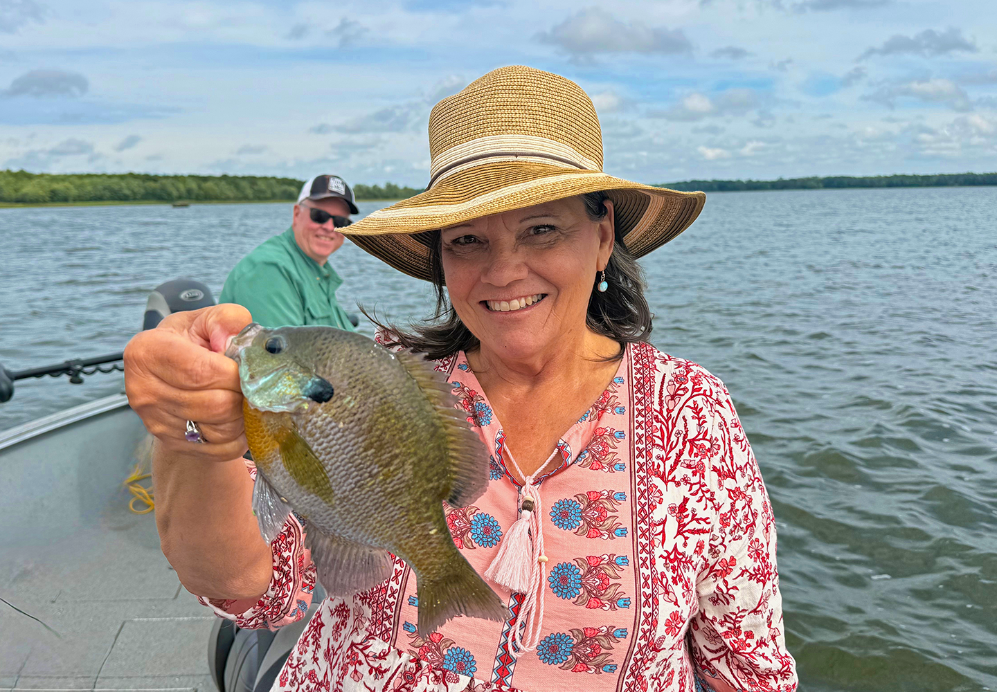 image of the Hippie Chick with huge bluegill and Gary Sundin in background 